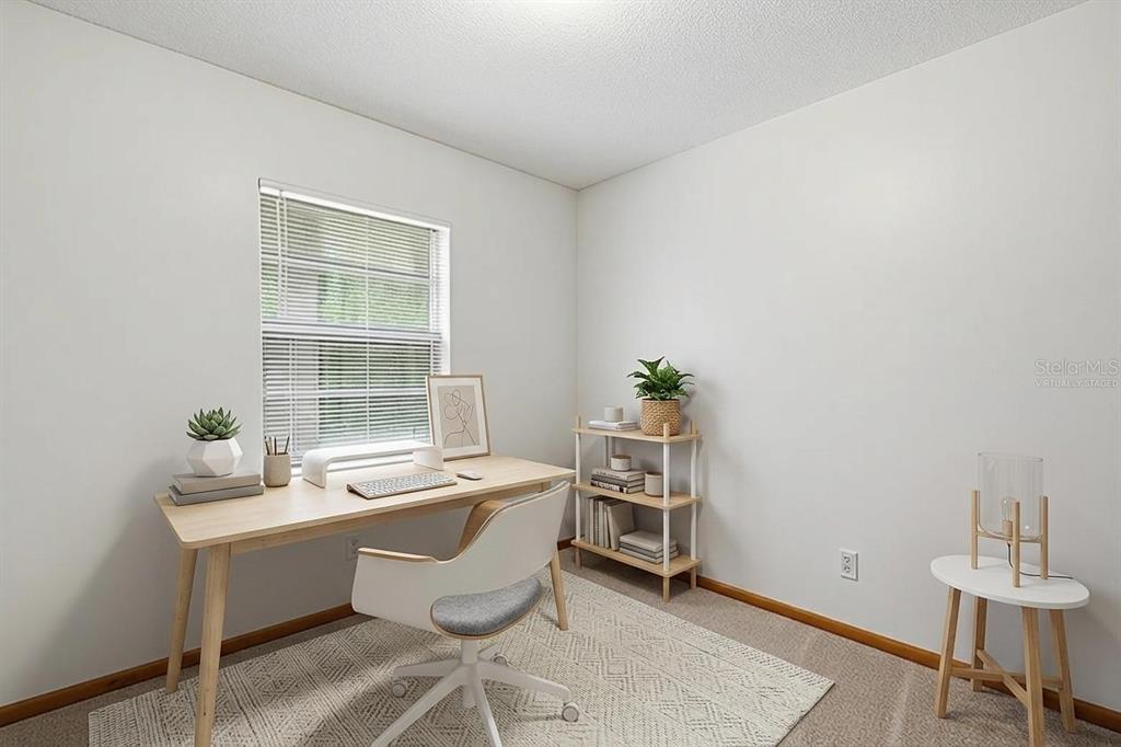 A home office with a desk, chair, shelving unit, and a window with blinds — 10207 N HYALEAH ROAD, TAMPA, FL