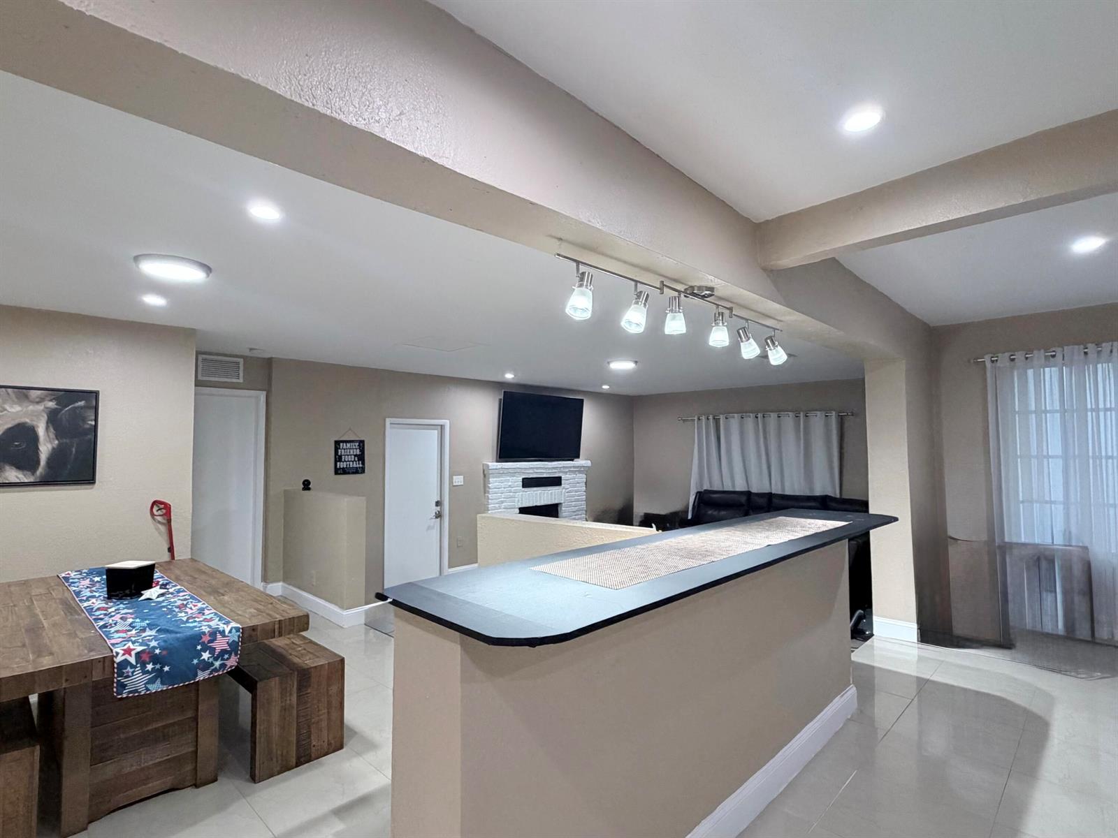 A dining area and kitchen island feature wooden furniture, tile flooring, and recessed lighting — 2000 SW 95th Terrace, Miramar FL 33025, MIRAMAR, FL