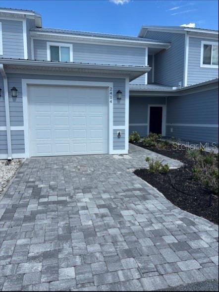 A light blue two-story townhouse with a single-car garage and a gray paver driveway — 2414 WILLOW WAY, WINTER HAVEN, FL