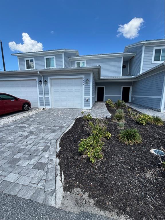 A two-story blue house with a paved driveway, a garage, and a landscaped front yard — 2414 WILLOW WAY, WINTER HAVEN, FL