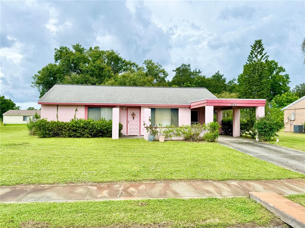 A single-story pink house with a gray shingled roof and an attached carport — 3941 NEKOOSA STREET, NORTH PORT, FL
