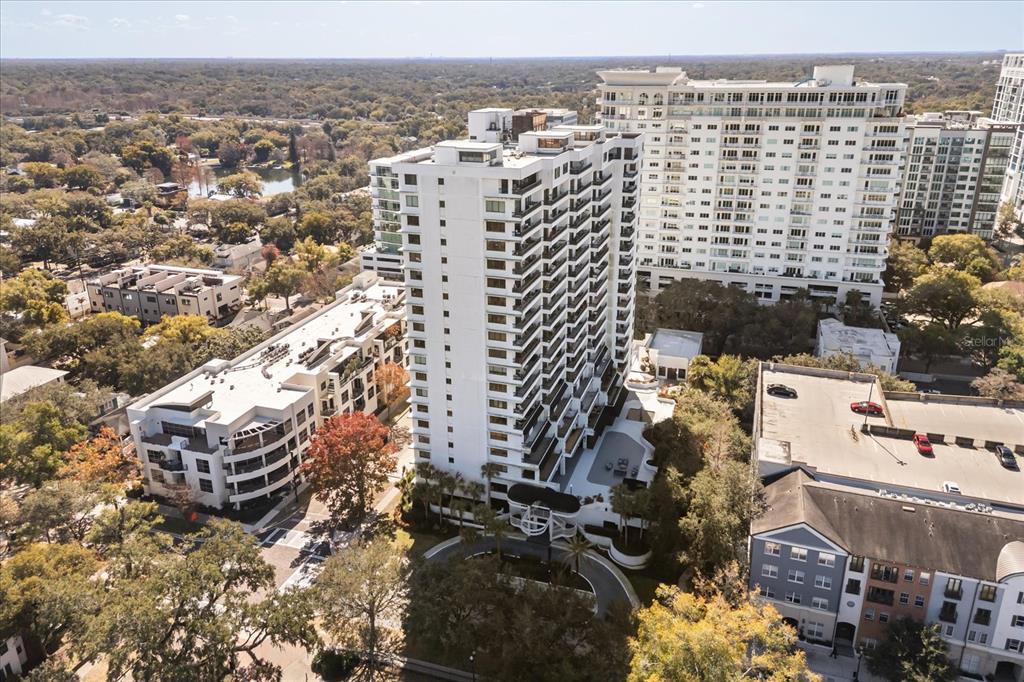 An aerial view shows a tall white apartment building surrounded by trees and other structures — 530 E CENTRAL BOULEVARD UNIT 1901, ORLANDO, FL