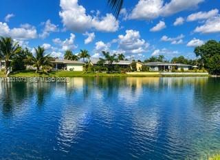 A view of houses across a lake under a blue sky with scattered clouds — 7551 SW 42nd Pl, Davie FL 33314, DAVIE, FL