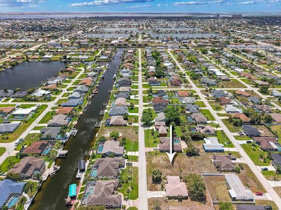 An aerial view shows a vacant residential lot situated between two houses in a neighborhood — 4406 SW 5TH PLACE, CAPE CORAL, FL