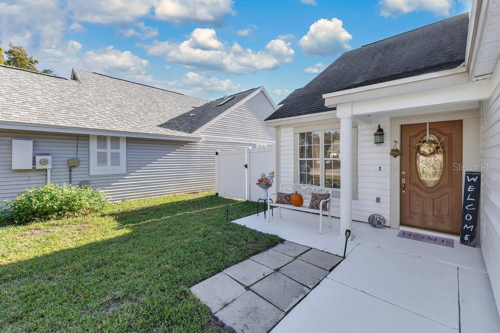 A white house exterior features a front porch with a bench and a welcome sign — 2640 WAYMEYER DRIVE, ORLANDO, FL