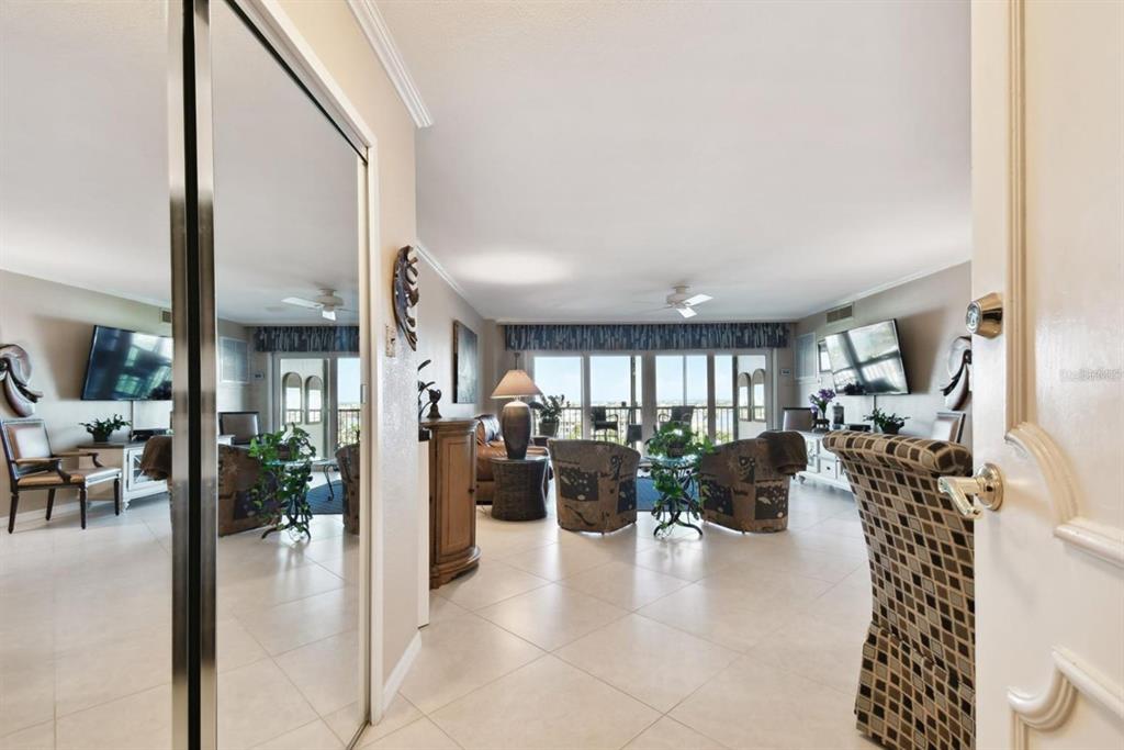 A view from a doorway into a living room with tile floors and balcony access — 10355 PARADISE BOULEVARD UNIT 702, TREASURE ISLAND, FL