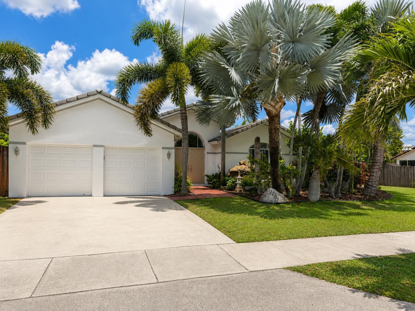 A white single-story house with a two-car garage and palm trees in the front yard — 17202 SW 149th Place, Miami FL 33187, MIAMI, FL