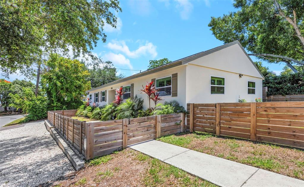 A single-story house with light-colored stucco walls and a horizontal wood fence in front — 710 31ST AVENUE N, ST PETERSBURG, FL