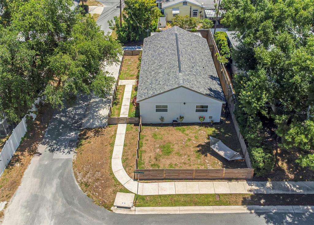 An aerial view shows a house with a gray roof, a fenced yard, and a walkway — 710 31ST AVENUE N, ST PETERSBURG, FL