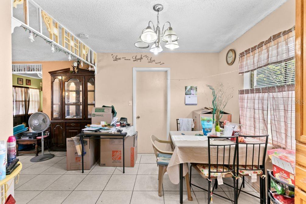 A dining room with tile floors, a chandelier, and a table surrounded by chairs — 1211 POPPY AVENUE, ORLANDO, FL