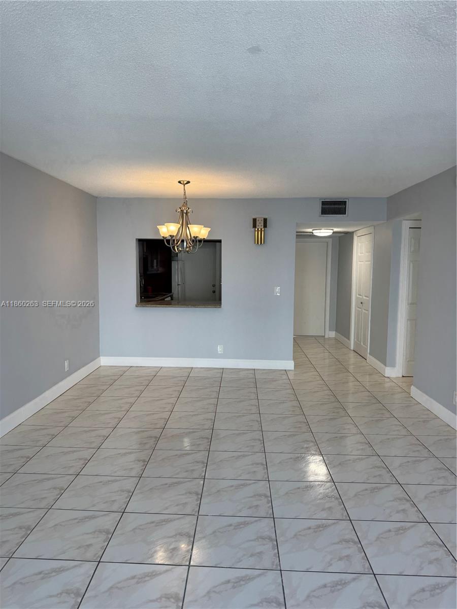 A dining area features light gray walls, white baseboards, and large marble-patterned floor tiles — 215 SE 3rd Ave # 305A, Hallandale Beach FL 33009, HALLANDALE BEACH, FL