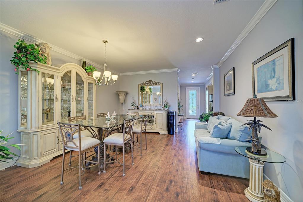 A dining room with a glass table and hutch flows into a living area — 11101 58TH STREET CIRCLE E, PARRISH, FL