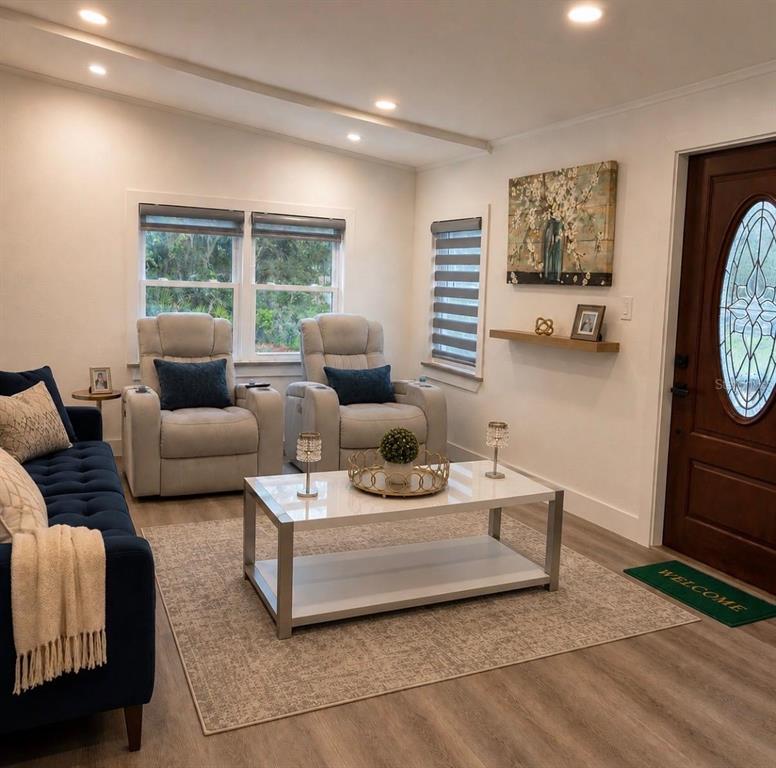 A living room features a blue sofa, two light-colored recliners, and a white coffee table — 4 EDEN CEMETERY ROAD, FROSTPROOF, FL