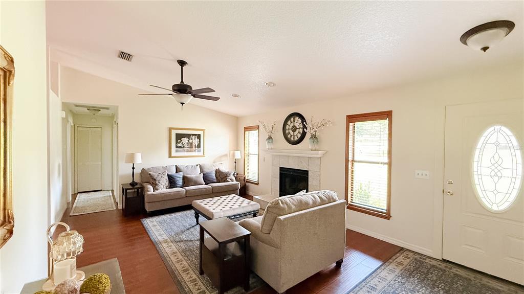 A living room features a fireplace, a sofa, an armchair, and hardwood floors — 898 CRITTENDEN AVENUE, ORANGE CITY, FL