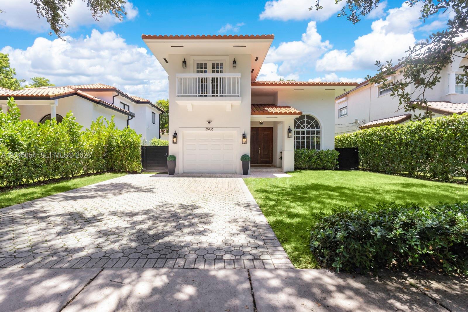 A two-story house with a white stucco facade, a tiled roof, and a paved driveway — 3908 Anderson Rd, Coral Gables FL 33134, CORAL GABLES, FL