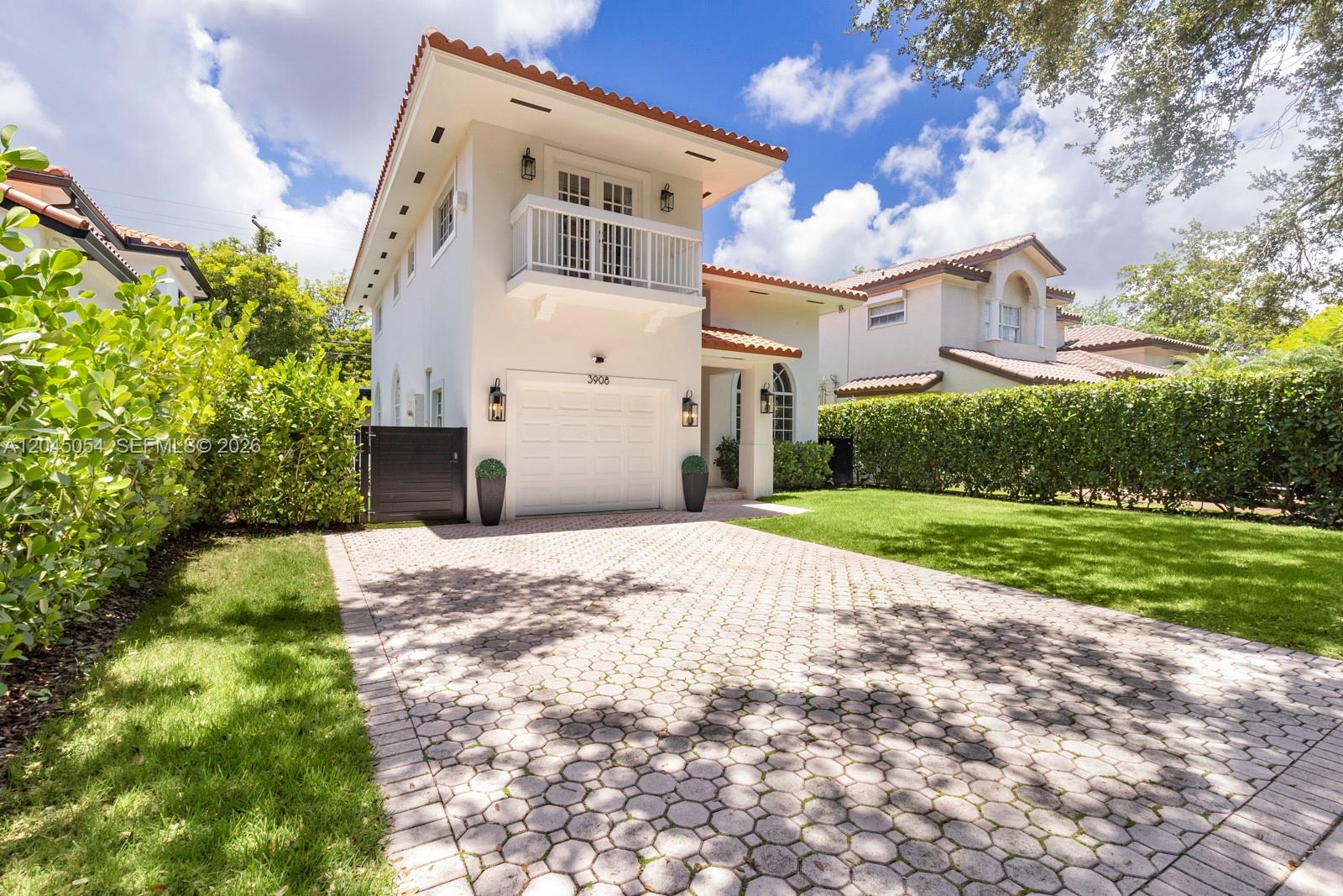 A two-story house with a white stucco exterior, a tile roof, and a paved driveway — 3908 Anderson Rd, Coral Gables FL 33134, CORAL GABLES, FL