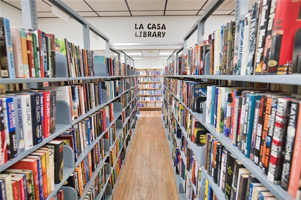 A library aisle features rows of bookshelves filled with books on both sides — 207 LA ROSAS, NORTH PORT, FL