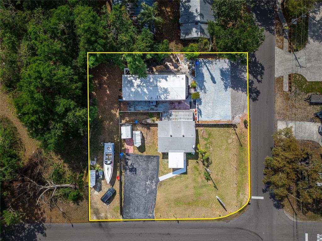 An aerial view shows a house with a driveway, boat, and yard within a property boundary — 126 RIDGEWOOD AVENUE, BRANDON, FL
