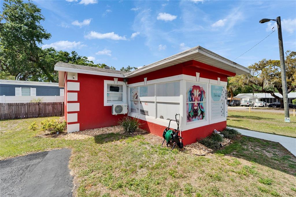 A bright red commercial building with white trim and a dog grooming sign — 126 RIDGEWOOD AVENUE, BRANDON, FL