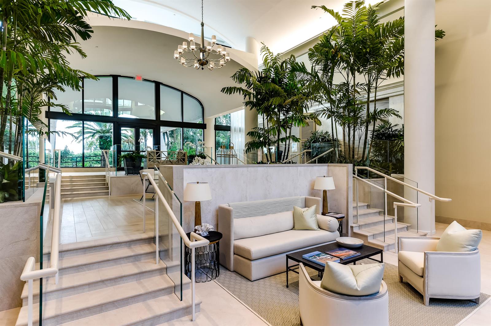 A bright hotel lobby features a seating area, indoor palm trees, and stone staircases — 2000 S Ocean Boulevard # 308n, Palm Beach FL 33480, PALM BEACH, FL