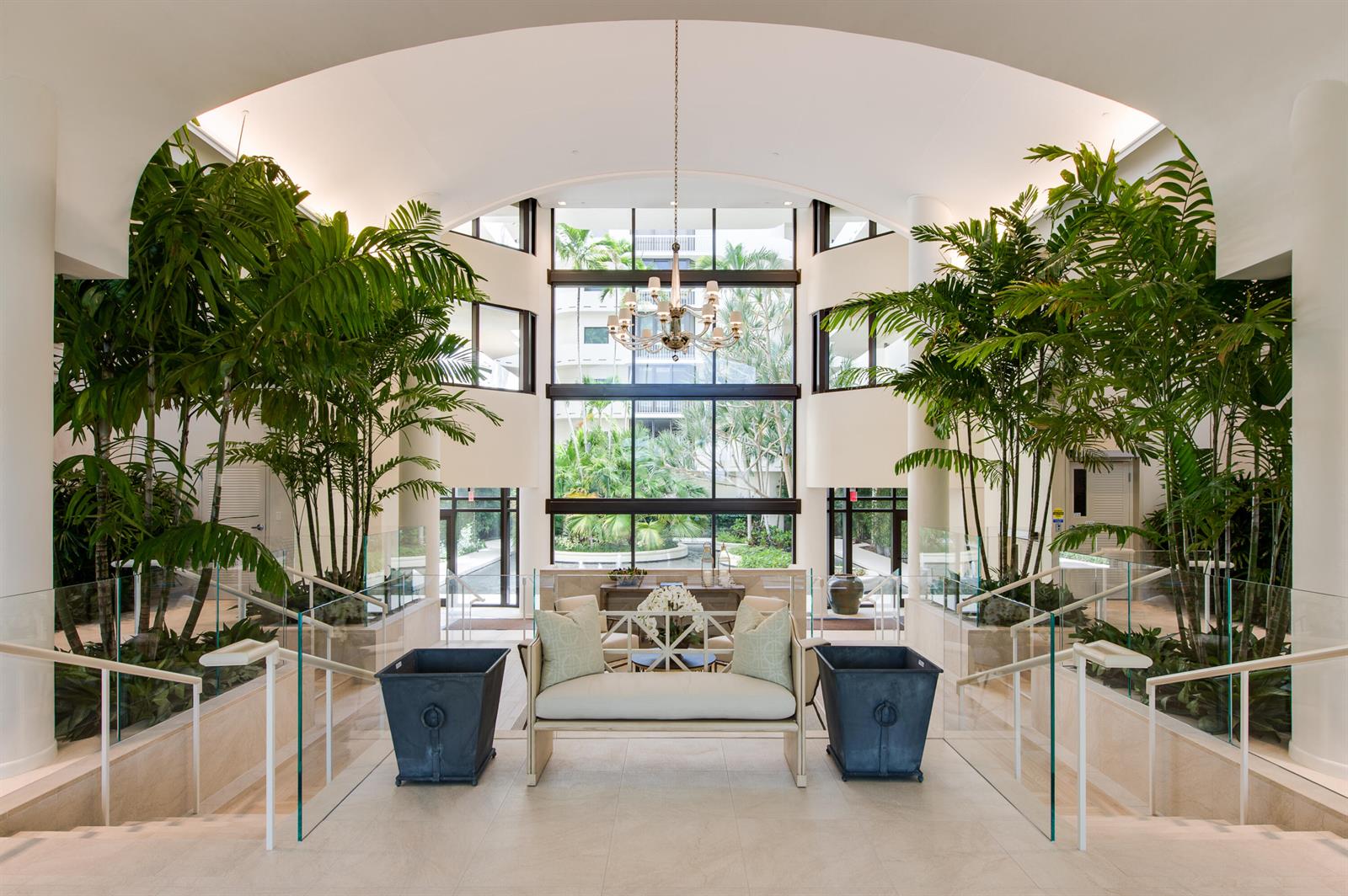 A bright, symmetrical lobby features a central bench, large potted palms, and a glass-walled atrium — 2000 S Ocean Boulevard # 308n, Palm Beach FL 33480, PALM BEACH, FL