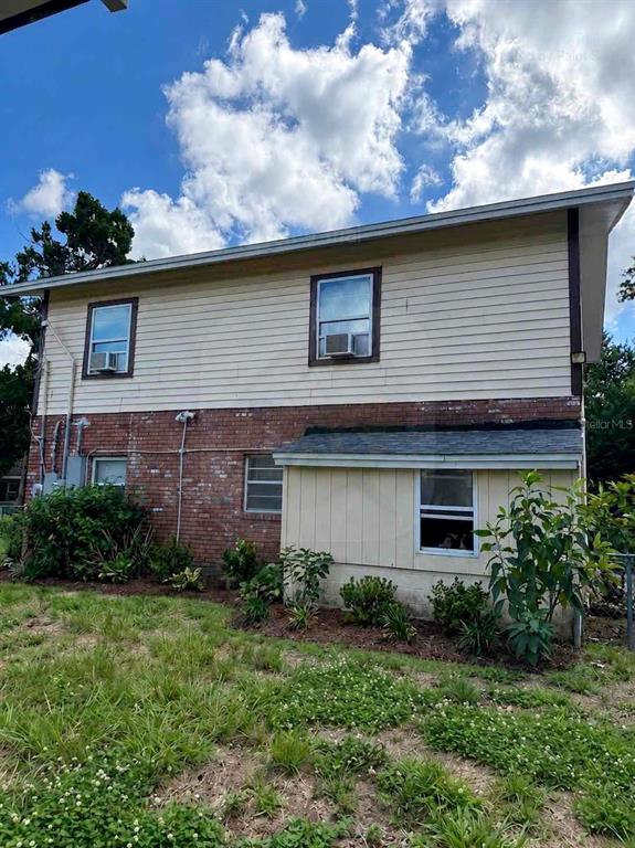 The exterior of a two-story house features a brick lower level and light-colored siding above — 3356 AVENUE Q NW, WINTER HAVEN, FL