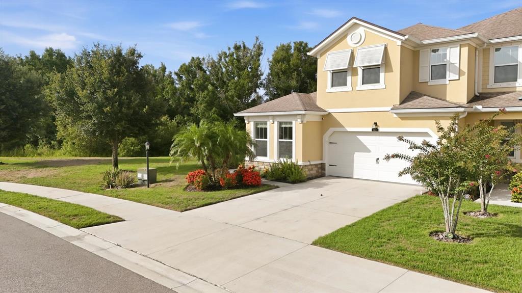 A two-story tan house with a white garage and a concrete driveway — 11474 ROLLING GREEN DRIVE, BRADENTON, FL