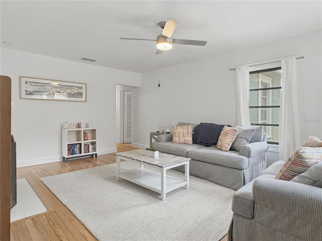 A living room features a gray sofa, a white coffee table, and a bookshelf — 2026 GROVE STREET, SARASOTA, FL