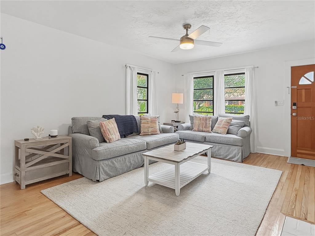 A living room features a gray sofa and loveseat, a coffee table, and hardwood floors — 2026 GROVE STREET, SARASOTA, FL