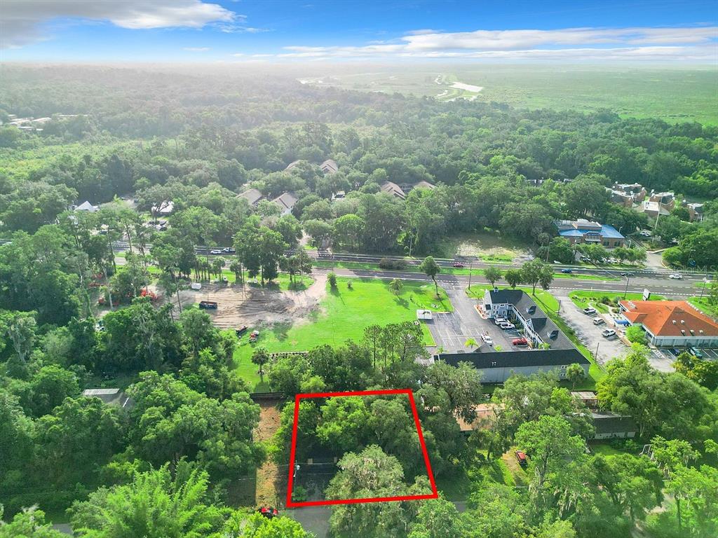 An aerial view shows a rectangular plot of land outlined in red amidst dense trees — 3729 SW 15 STREET, GAINESVILLE, FL