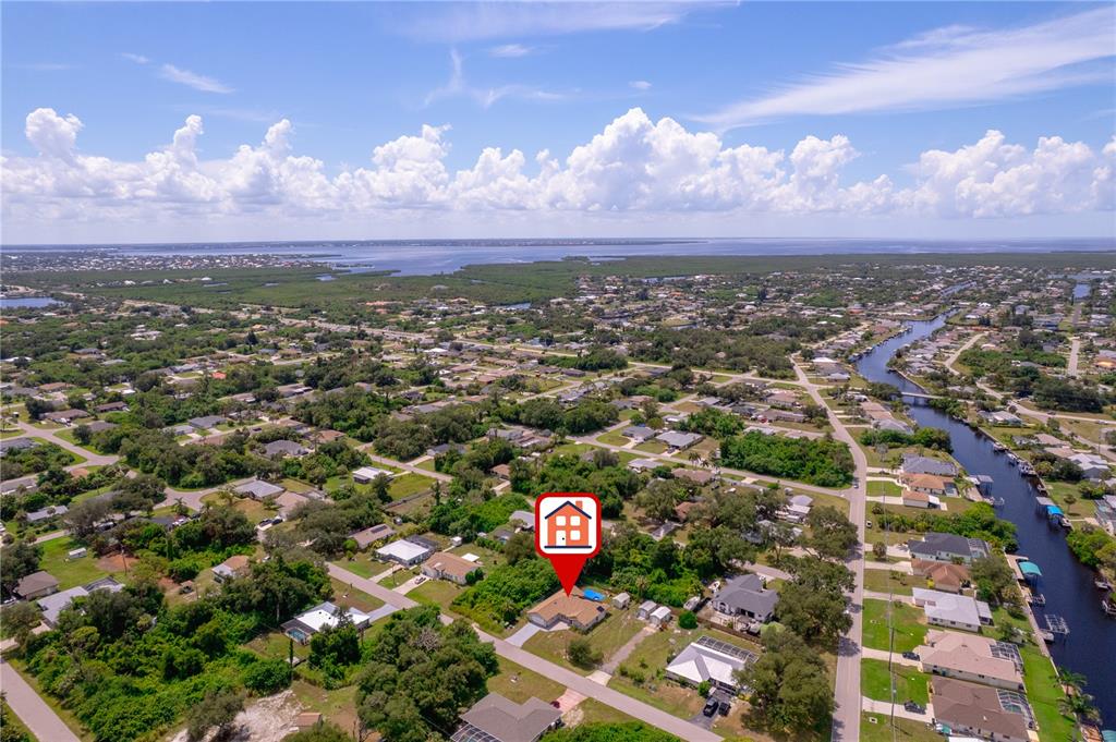 An aerial view shows a single-story house marked with a red icon in a neighborhood — 1157 BEAUMONT AVENUE, PORT CHARLOTTE, FL
