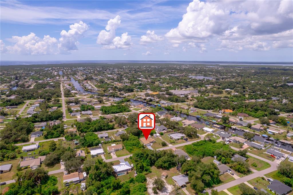 An aerial view shows a residential neighborhood with a red house icon marking a property — 1157 BEAUMONT AVENUE, PORT CHARLOTTE, FL