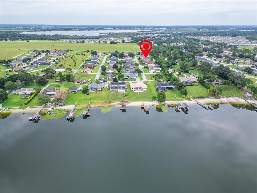 An aerial view shows a residential neighborhood with houses situated along a lakefront — 170 OLD NICHOLS CIRCLE, AUBURNDALE, FL