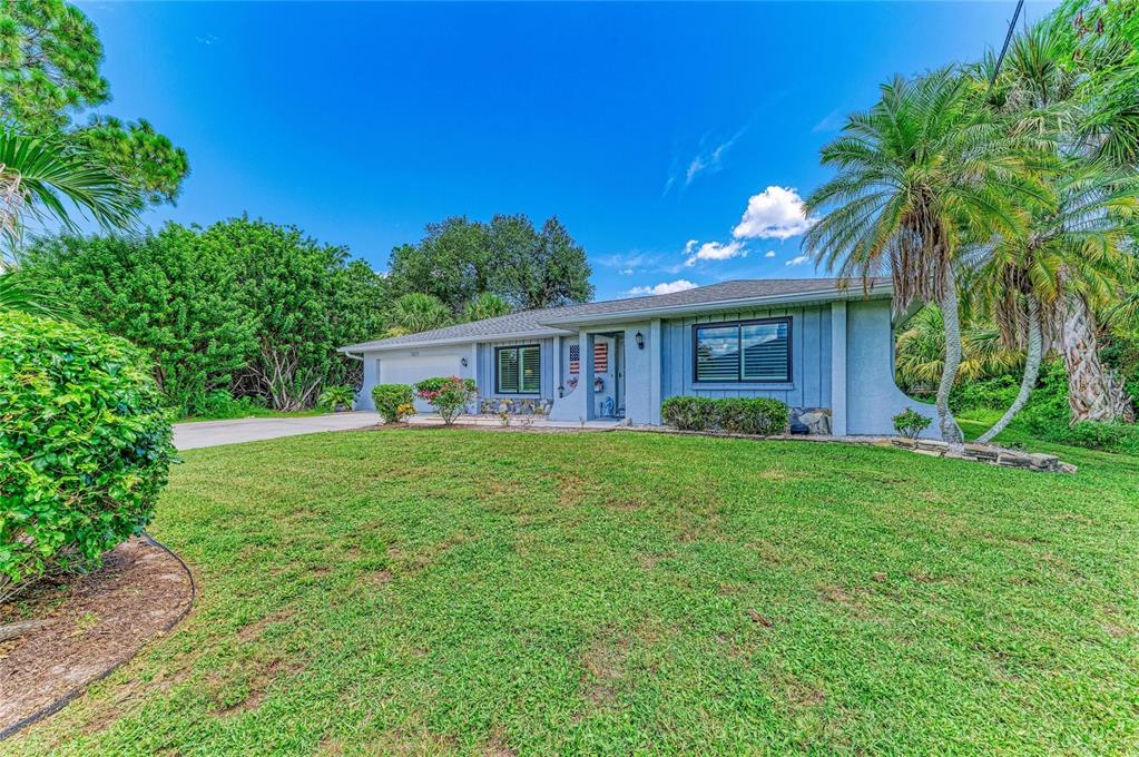 A single-story house with blue siding, a front porch, and a large lawn — 18565 EDGEWATER DRIVE, PORT CHARLOTTE, FL