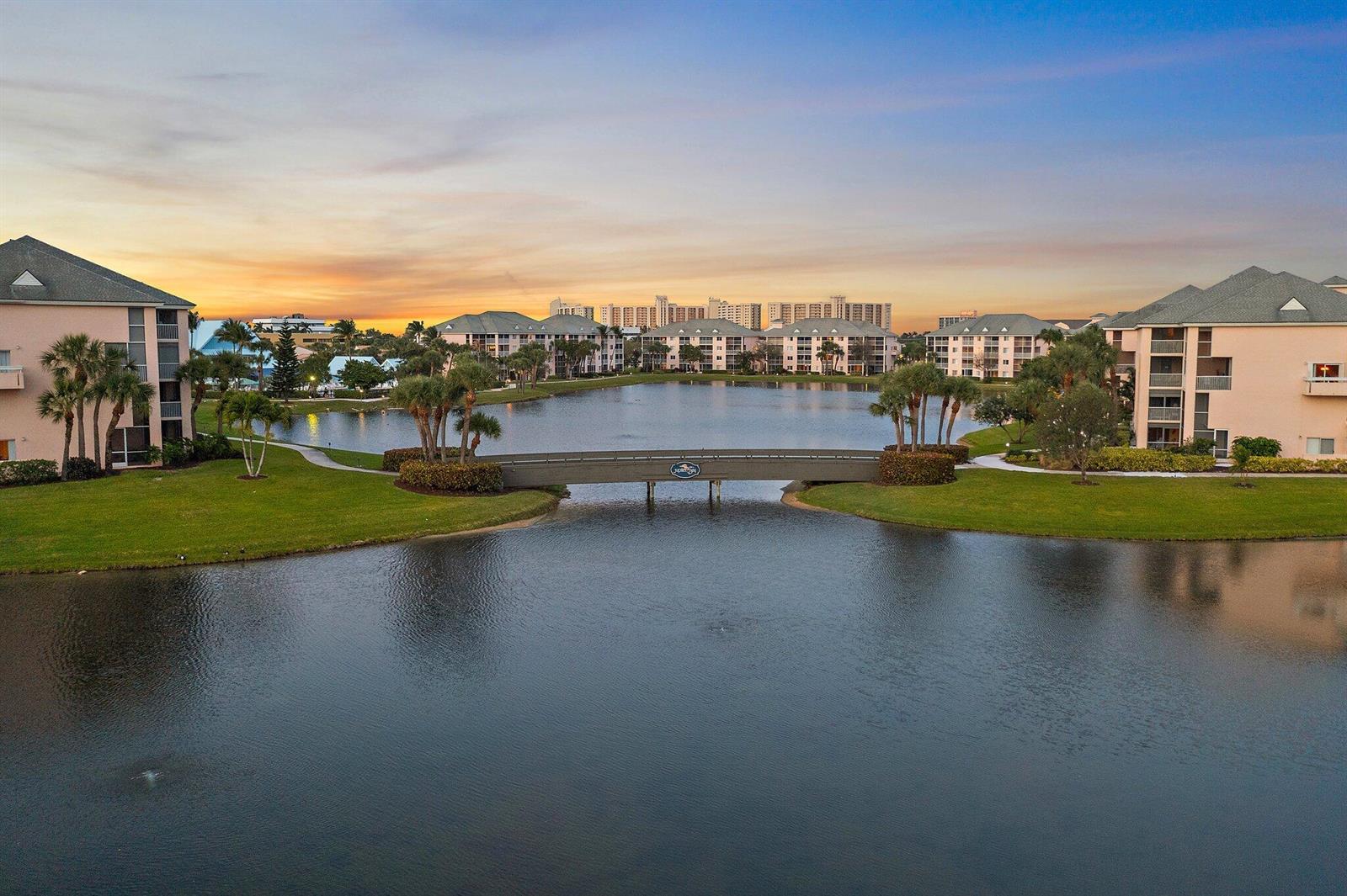 A sign for Jupiter Bay Condominium Association stands in a landscaped area with palm trees — 353 S Us-1 # C106, Jupiter FL 33477, JUPITER, FL