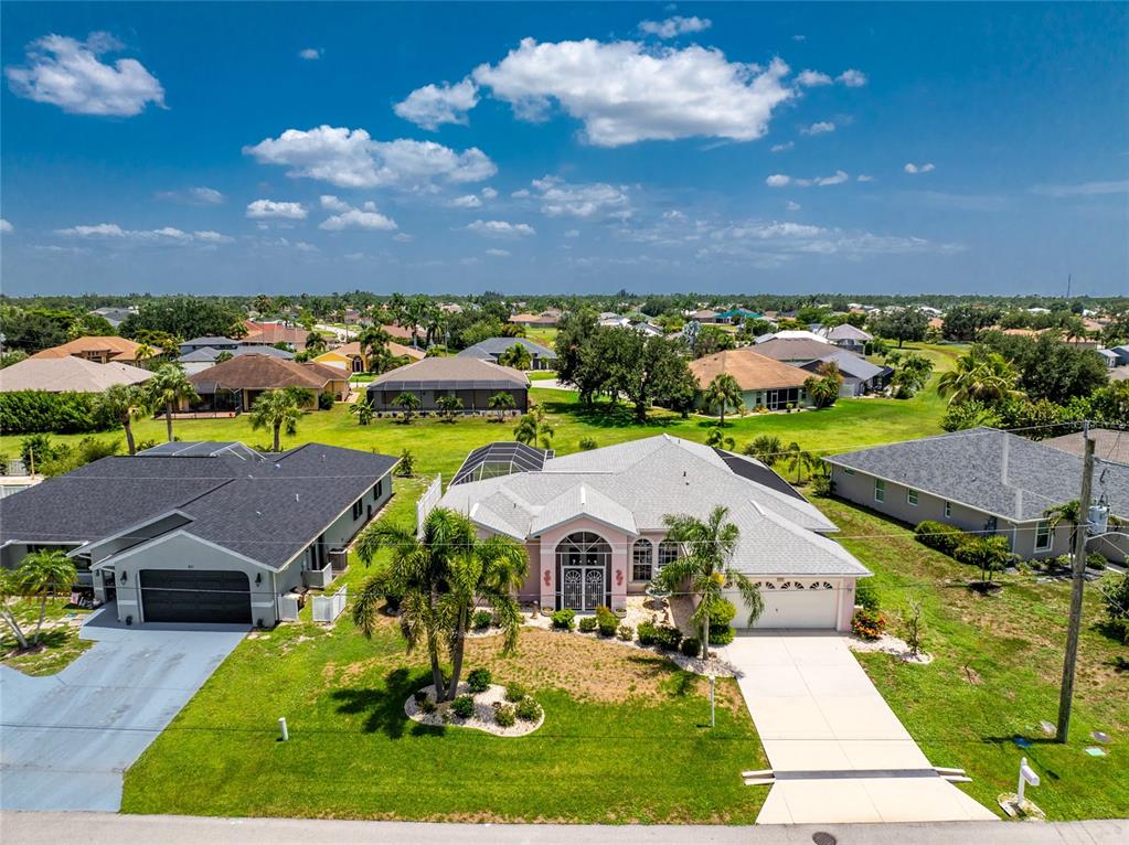An aerial view of a single-story house with a light-colored roof and palm trees — 417 SCARLET SAGE, PUNTA GORDA, FL