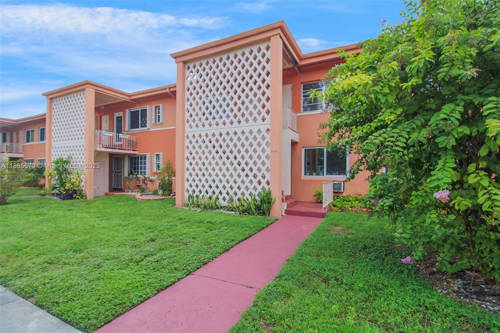 A two-story peach-colored apartment building features white lattice screens and a red walkway — 3451 SW 11th St # 8A, Miami FL 33135, MIAMI, FL