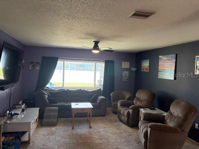 A living room features a dark sofa, two recliners, a coffee table, and a television — 1381 EAGLE STREET, PORT CHARLOTTE, FL