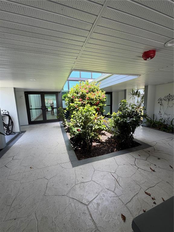 An outdoor courtyard features a central garden bed surrounded by a stamped concrete patio — 21287 GERTRUDE AVENUE UNIT 215, PORT CHARLOTTE, FL