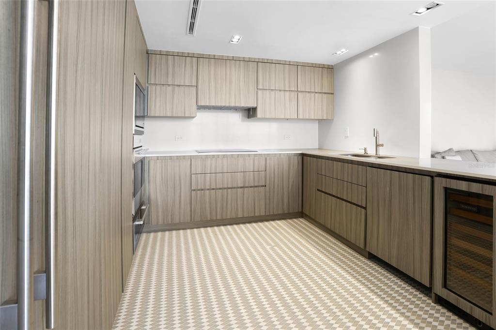 A modern kitchen features light wood cabinetry, white countertops, and a patterned tile floor — 860 ASHFORD AVENUE #5C UNIT #1 UNIT 1, SAN JUAN, PR