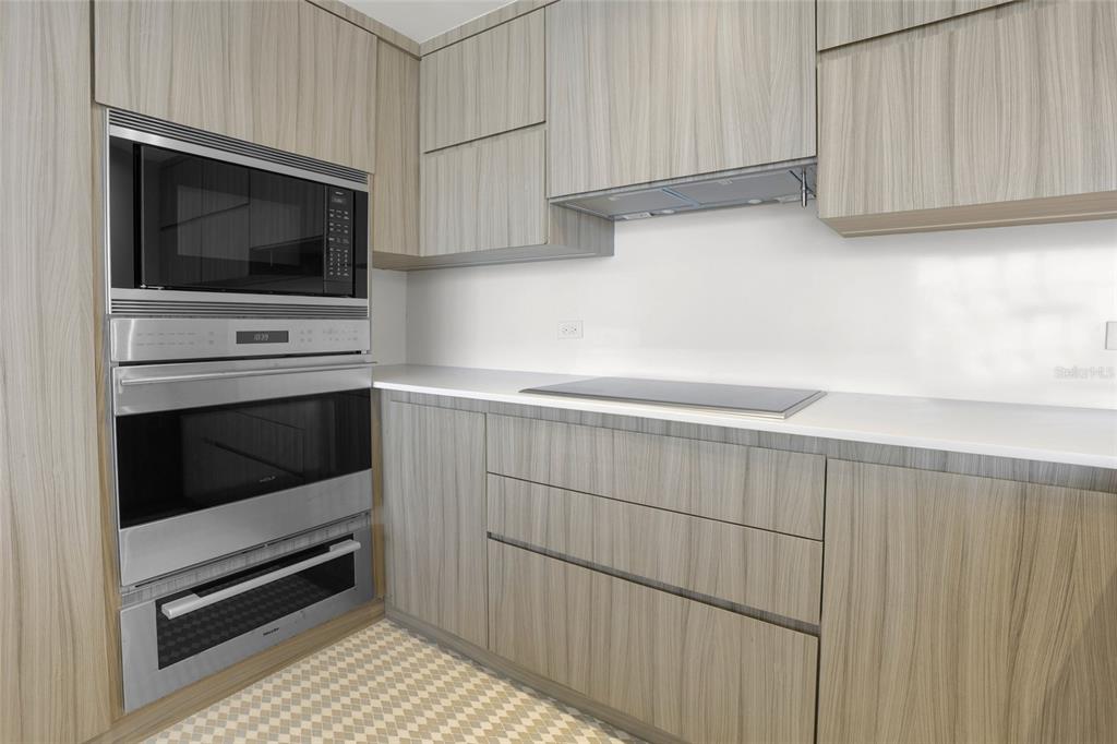 A modern kitchen features light wood-grain cabinets, stainless steel appliances, and a white countertop — 860 ASHFORD AVENUE #5C UNIT #1 UNIT 1, SAN JUAN, PR