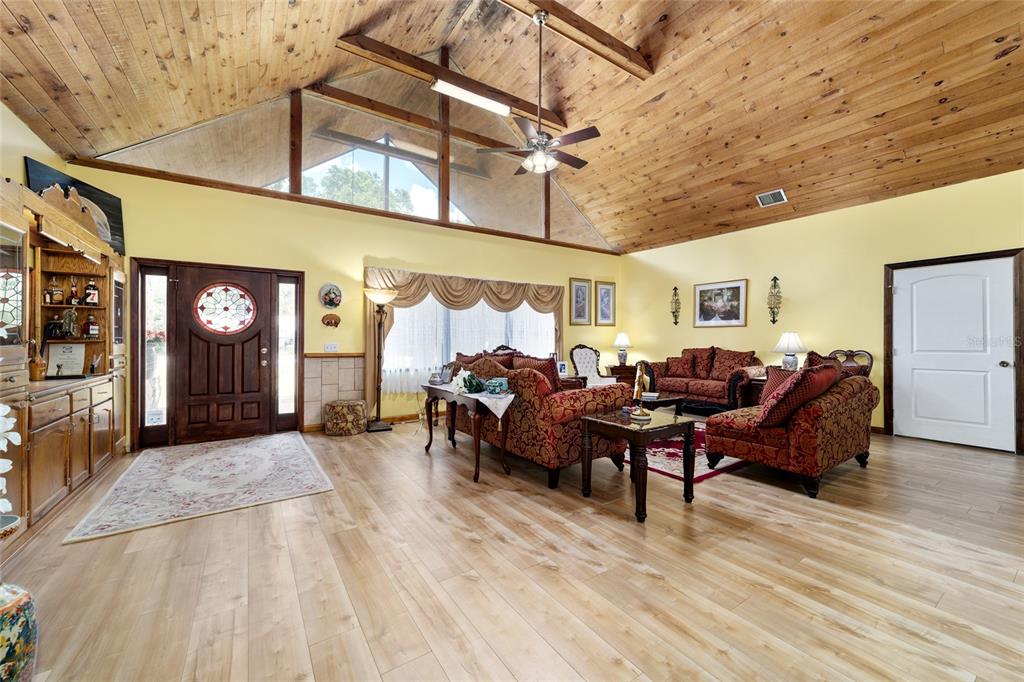 A screened-in swimming pool with a small waterfall feature and a red concrete patio — 5300 NE 2ND LANE, OCALA, FL