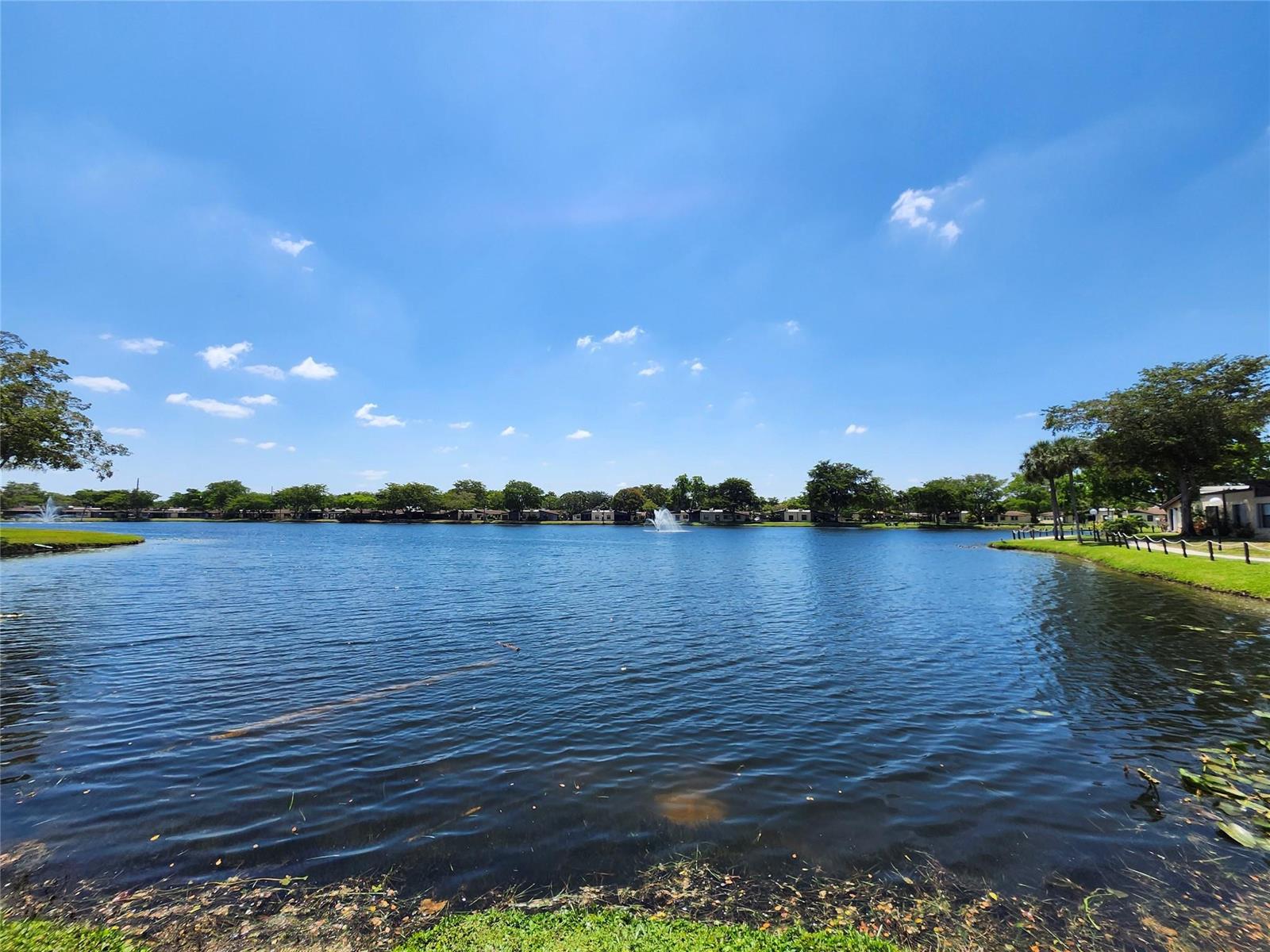 A wide lake with a fountain is surrounded by trees and residential buildings — 301 Cambridge Road # 301, Hollywood FL 33024, HOLLYWOOD, FL