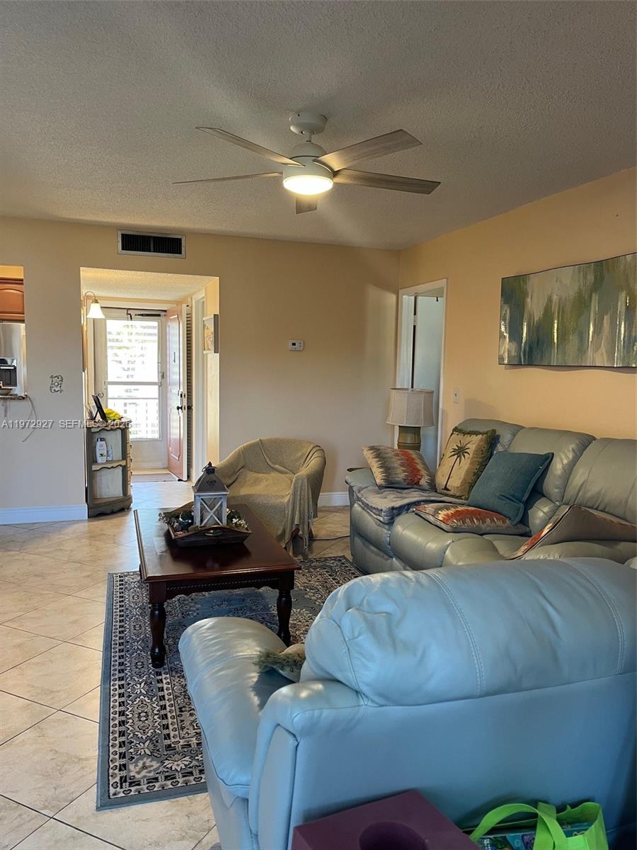A living room features light-colored tile floors, a ceiling fan, and a light blue sofa — 752 Lori Dr # 218, Palm Springs FL 33461, PALM SPRINGS, FL