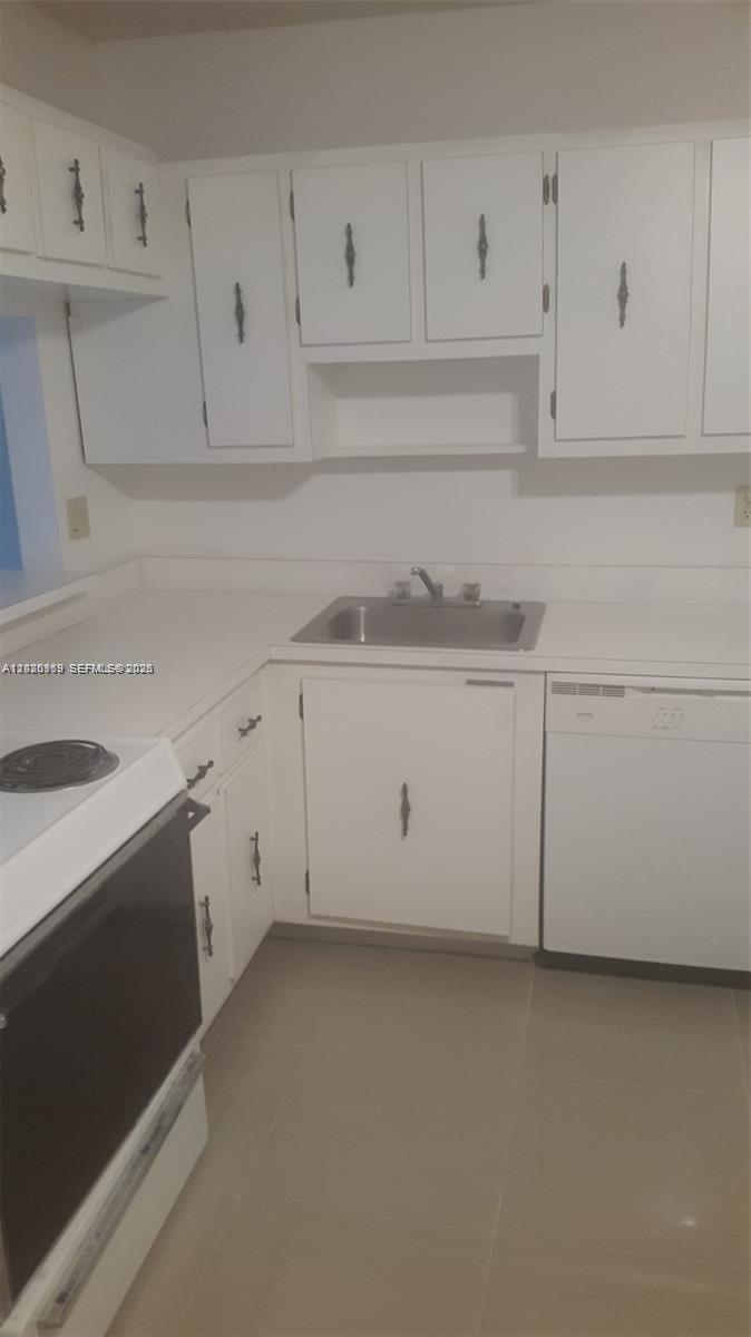 A kitchen features white cabinets, a stainless steel sink, and a white dishwasher — 4384 NW 9th Ave # 3B, Deerfield Beach FL 33064, DEERFIELD BEACH, FL