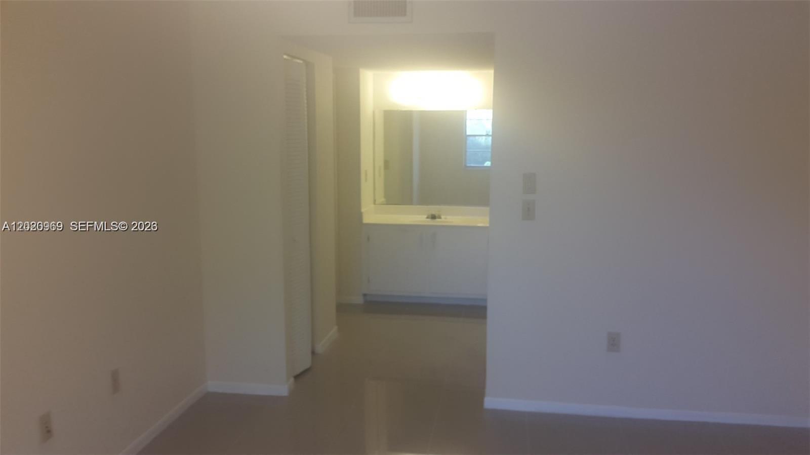A view from a room looking into a bathroom with a vanity and mirror — 4384 NW 9th Ave # 3B, Deerfield Beach FL 33064, DEERFIELD BEACH, FL