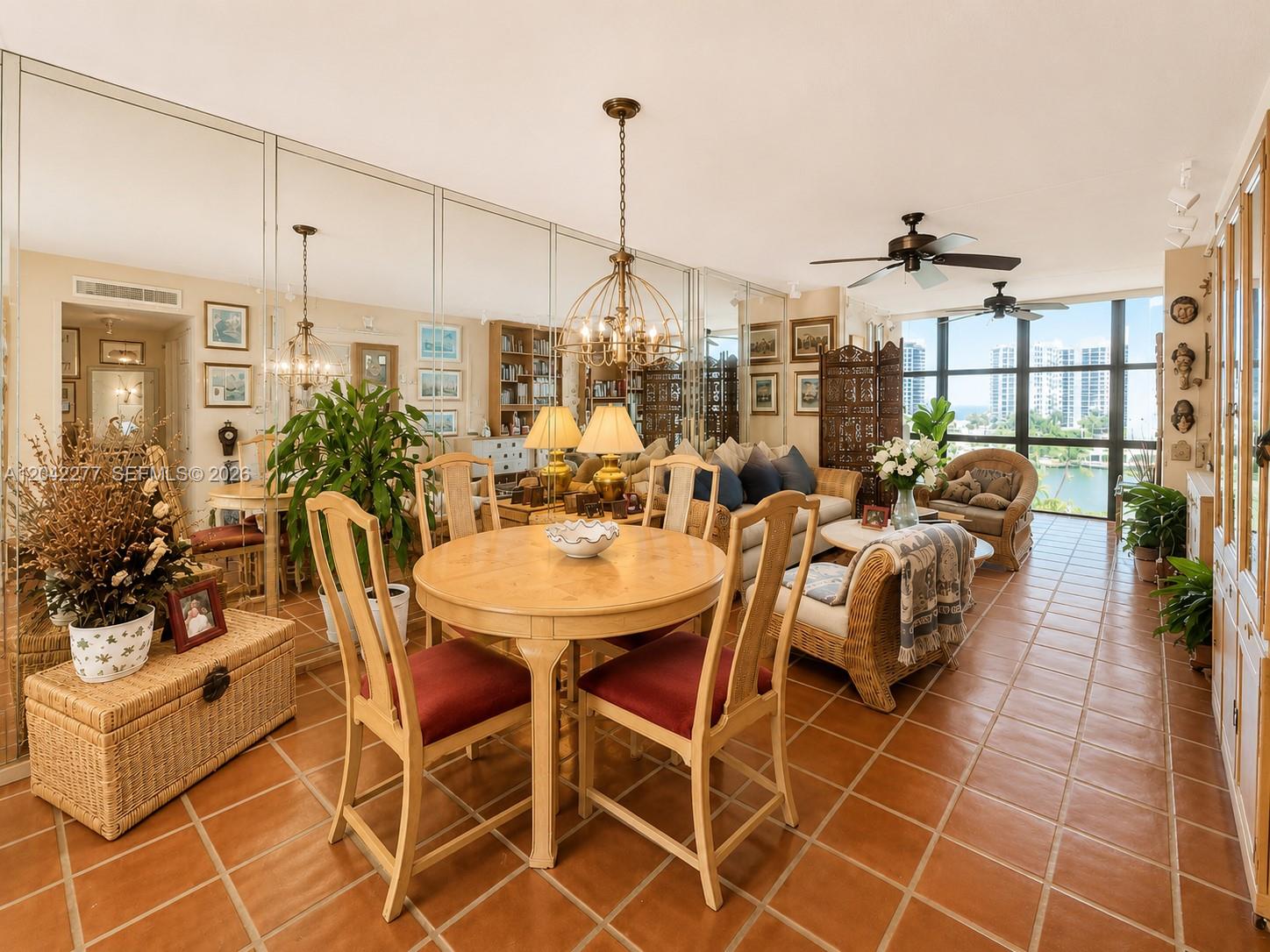 A dining and living area features tiled floors, mirrored walls, and a view of water — 1000 Parkview Dr # 726, Hallandale Beach FL 33009, HALLANDALE BEACH, FL