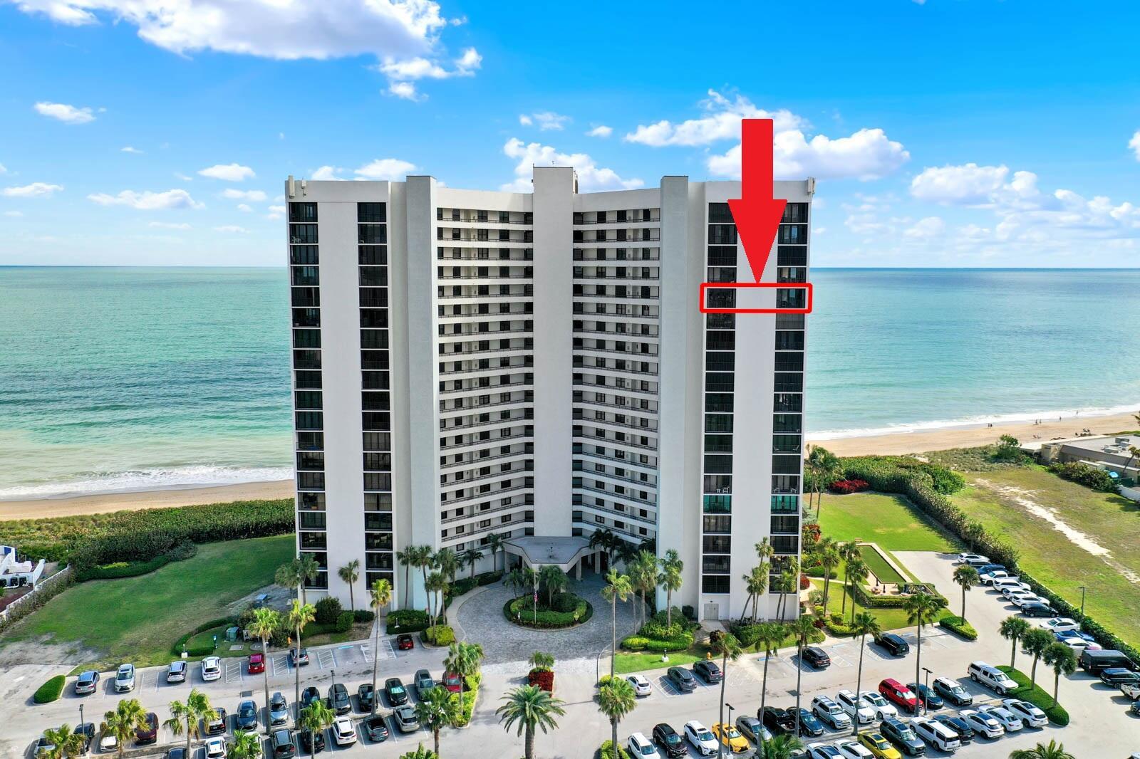 An aerial view of a tall beachfront condominium building with a red arrow pointing toward a balcony — 9650 S Ocean Drive # 1610, Jensen Beach FL 34957, JENSEN BEACH, FL