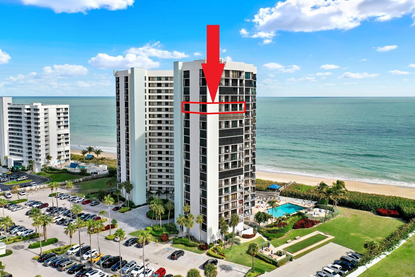 An aerial view shows a high-rise beachfront condominium building with a red arrow highlighting a balcony — 9650 S Ocean Drive # 1610, Jensen Beach FL 34957, JENSEN BEACH, FL