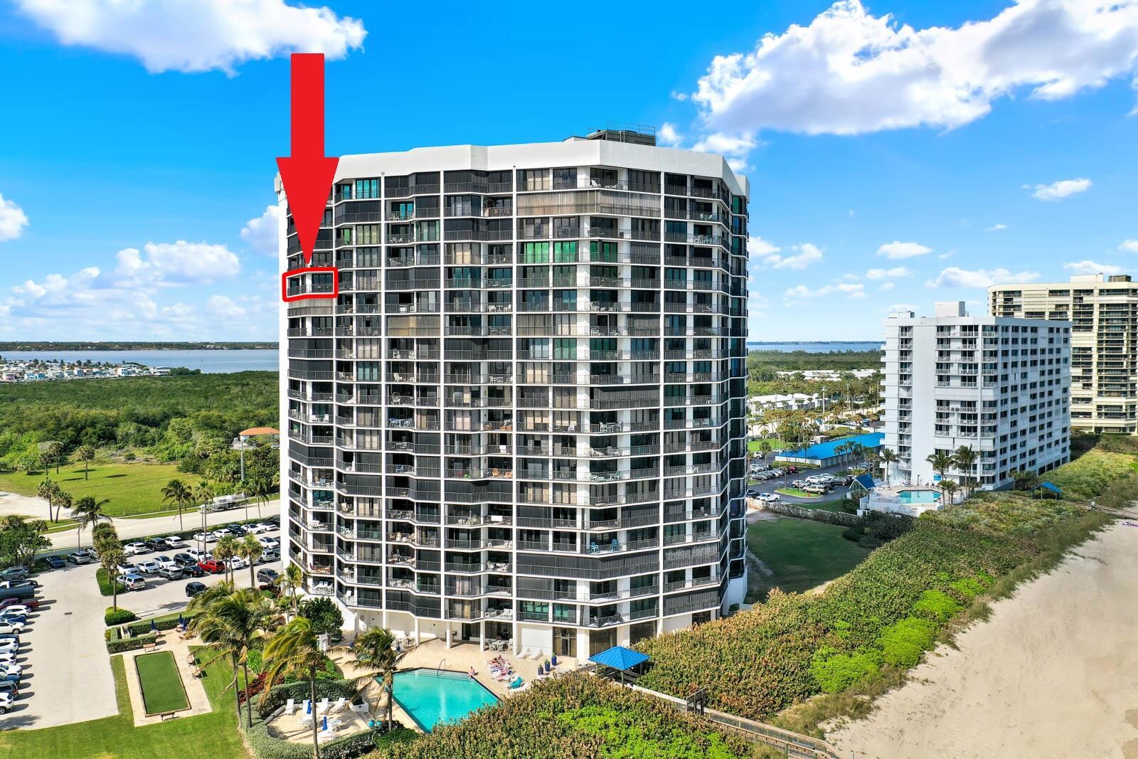 An exterior view of a high-rise beachfront condominium building with a red arrow pointing upward — 9650 S Ocean Drive # 1610, Jensen Beach FL 34957, JENSEN BEACH, FL
